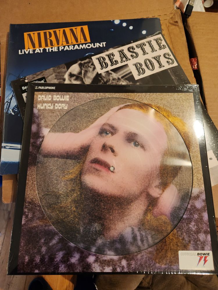 Three vinyl records. Nirvana Live at Paramount, Beastie Boys - Some Old Bullshit, and picture disk of Bowie - Hunky Dory