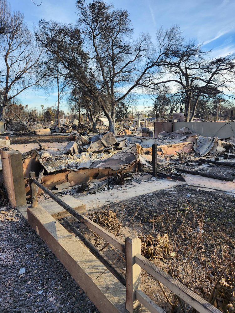 Only fence remaining in front of burned house.