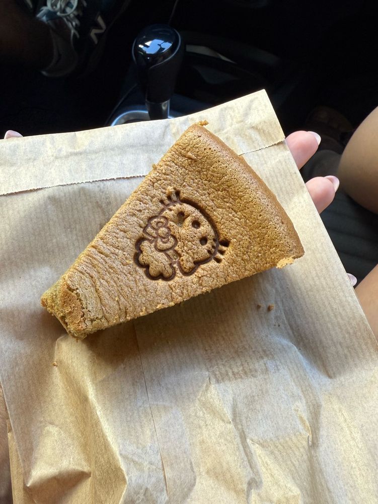 תמונה של הלו קיטי על עוגה שמונחת על שקית נייר חומה