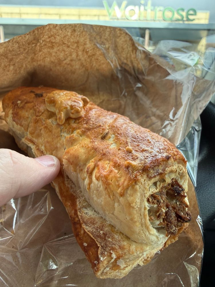 A sausage roll in a brown paper bag