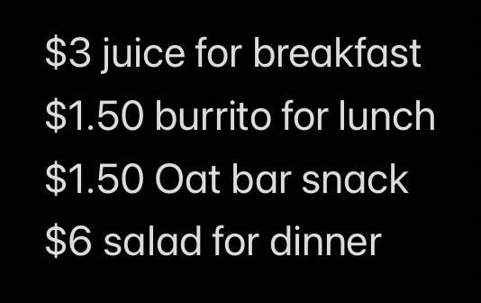 White text on a black background. A listing of Reklaw’s usual food for the day, with prices. The items: $3 juice for breakfast, $1.50 burrito for lunch, $1.50 oat bar snack, $6 salad for dinner. This sums to $12, a bit over Reklaw’s food assistance budget of about $10 per day.