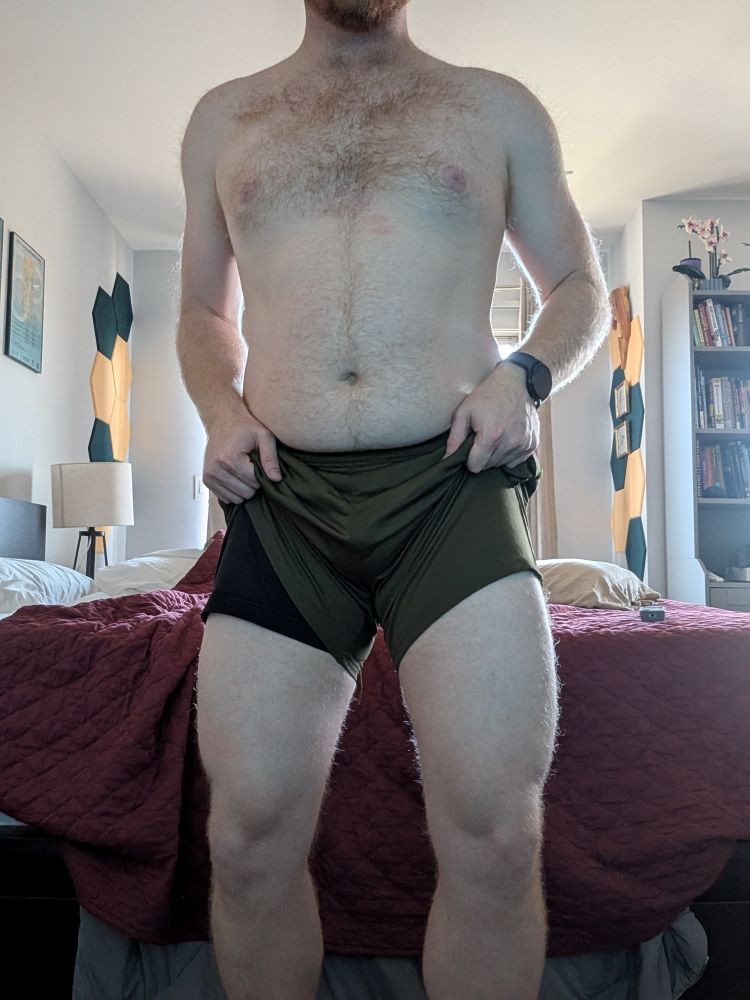 Picture of scooter shirtless raising his shorts revealing his swole quads after leg day. 