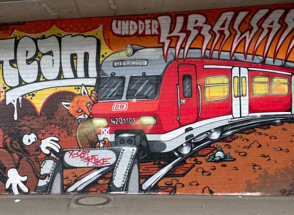Graffiti, roter DB Zug, mit Tieren, Fuchs, Affe am Rand, links steht Team, oben und der Krawass (?)