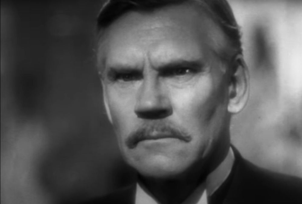A middle-aged dignified looking man, Walter Huston, looking stern and determined