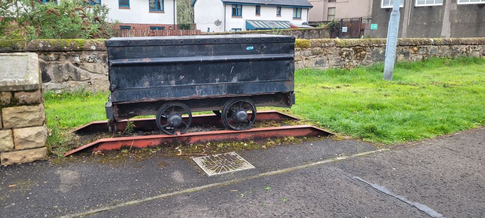 Replica of an enclosed coal wagon on a section of rail to mark the wagonway that transported coal from the colliery to the harbour.