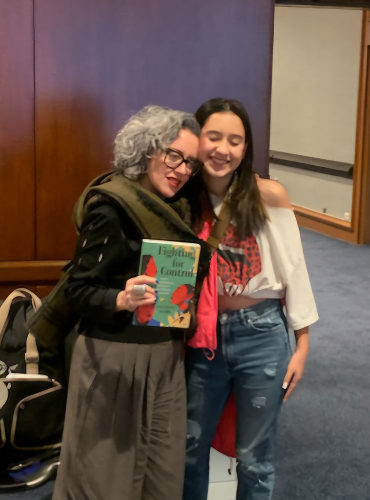 Me standing by my child holding my book. 