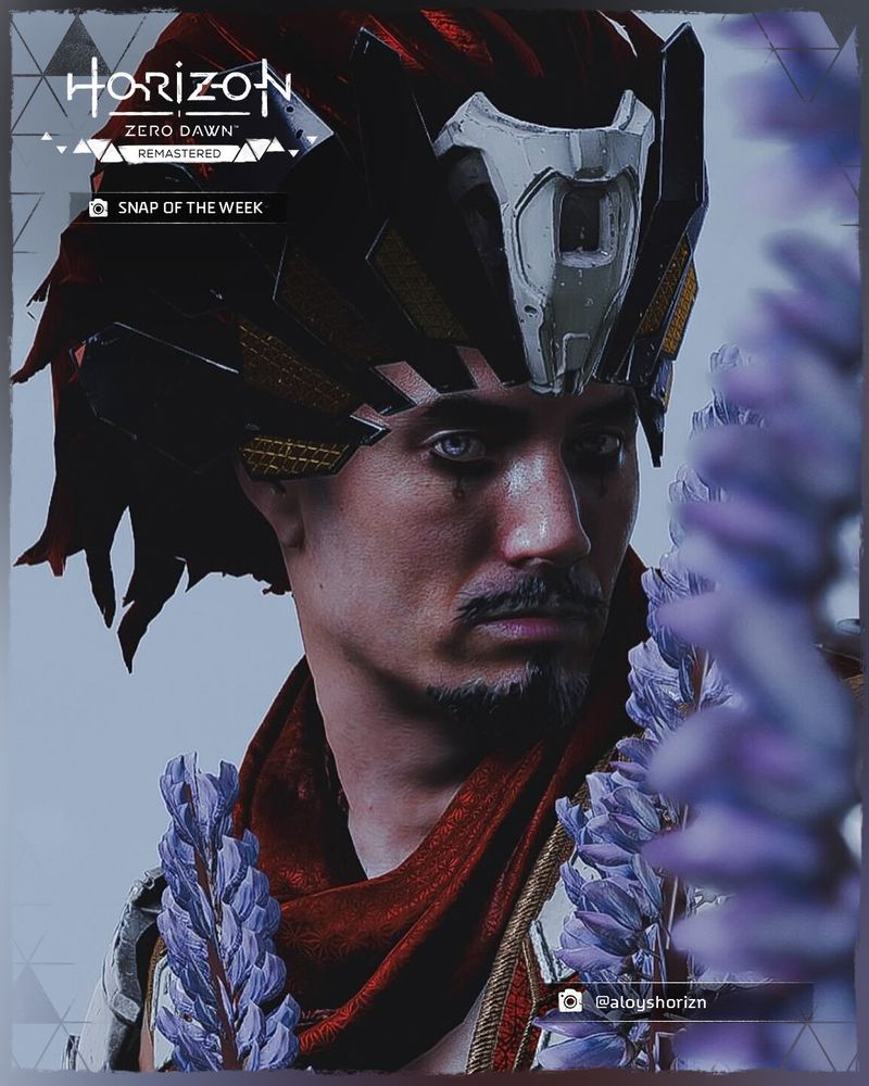 A screenshot taken in Horizon Zero Dawn Remastered of Nil looking directly at the camera, while surrounded by purple flowers.