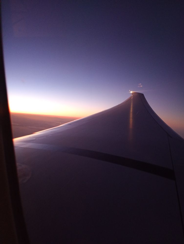 Foto del ala del avión con el atardecer de fondo