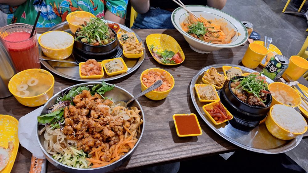 Spread of korean bbq at a restaurant. Includes large portions of bibimbap and bulgogi