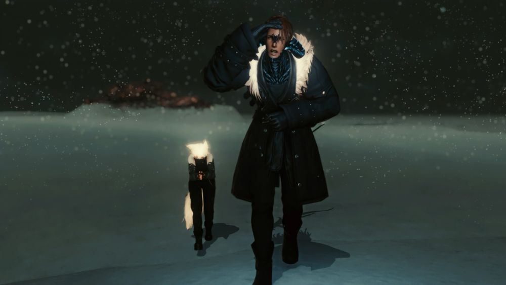 Close up shot of Ryder and Mist as they trudge through the cold. Mist is hunched over as they walk, shivering. Ryder Is a couple steps in front of Mist, his hand trying to shield his eyes from the snow as he tries to find the way through the falling snow.