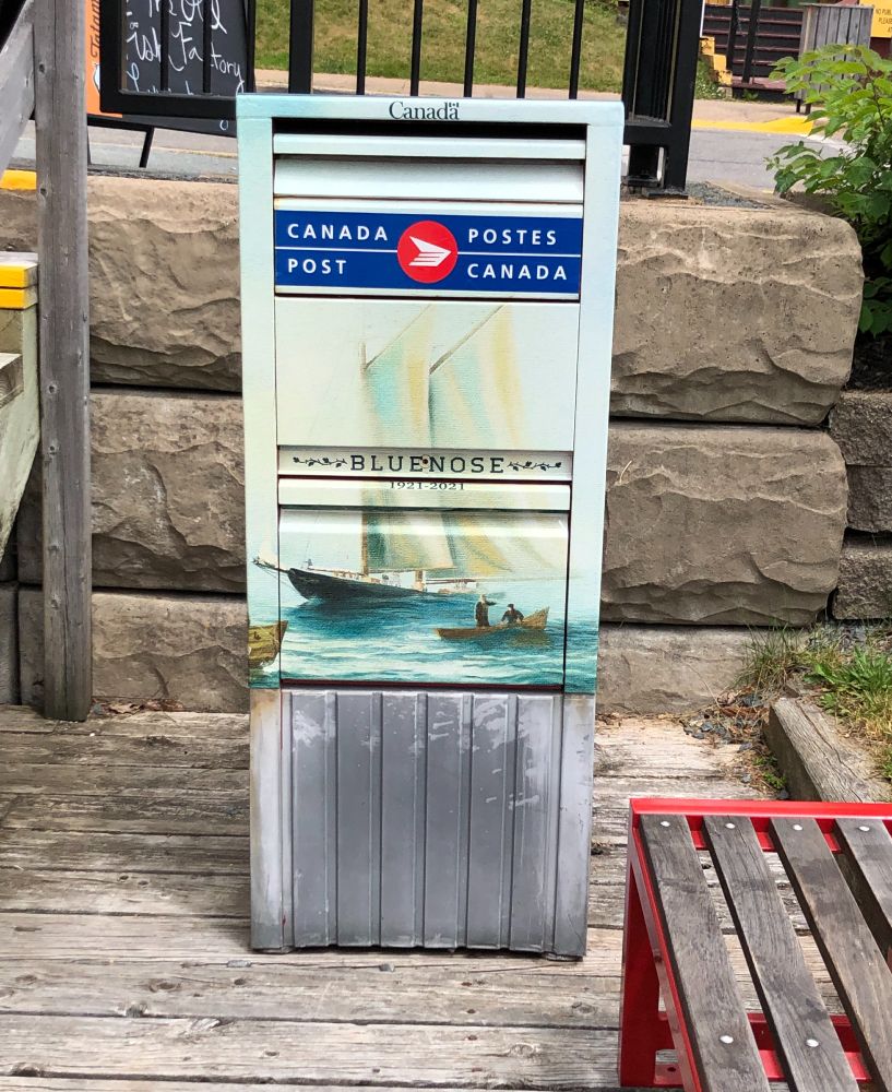 A Canada Post mailbox decorated with an image of the Bluenose schooner.
