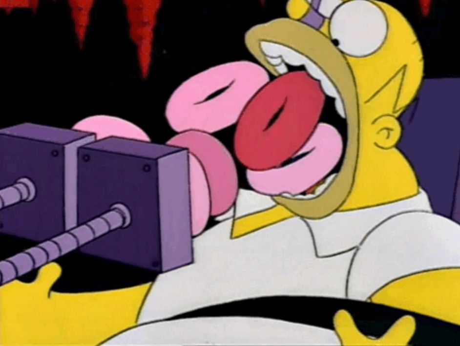 A still frame from the Simpsons, in which Homer is in hell, being force-fed donuts. 