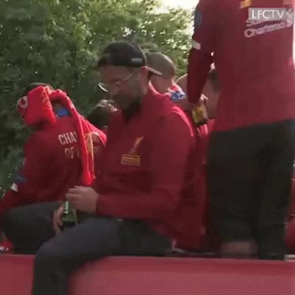 a man wearing a red jacket that says ' champions ' on it