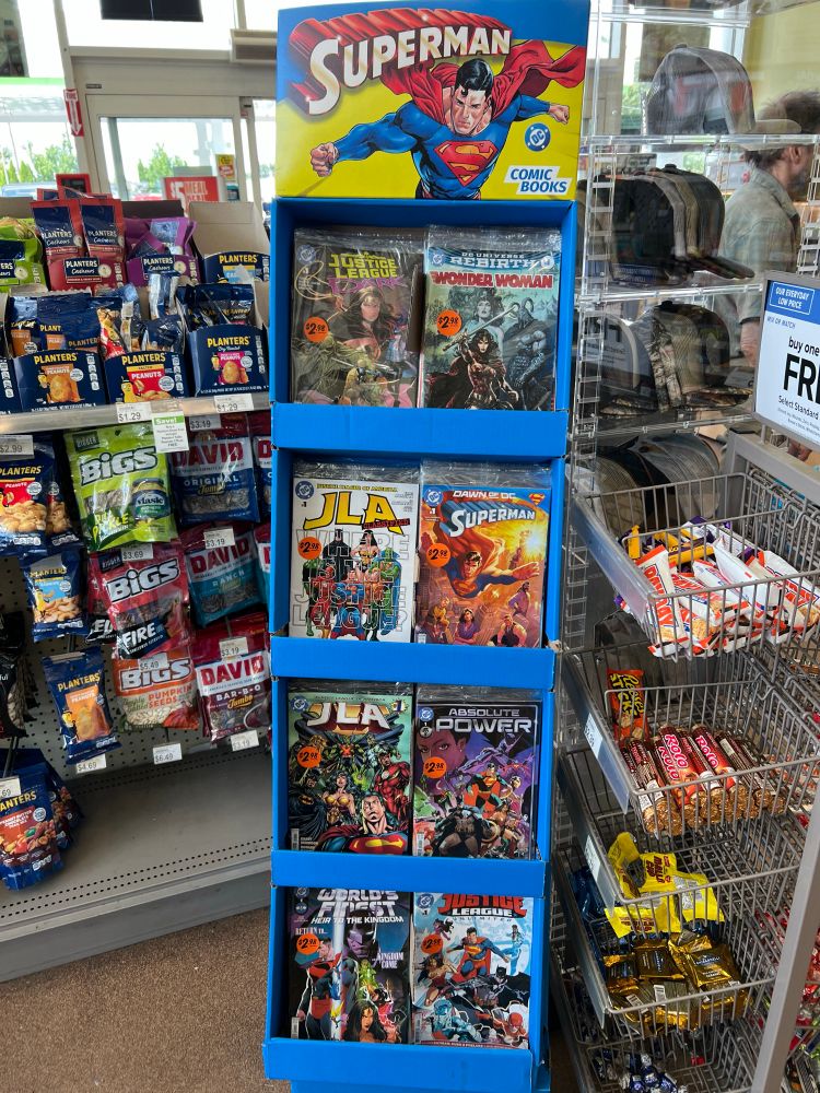 a dc comics display with stacks of individually wrapped comic books from different eras 