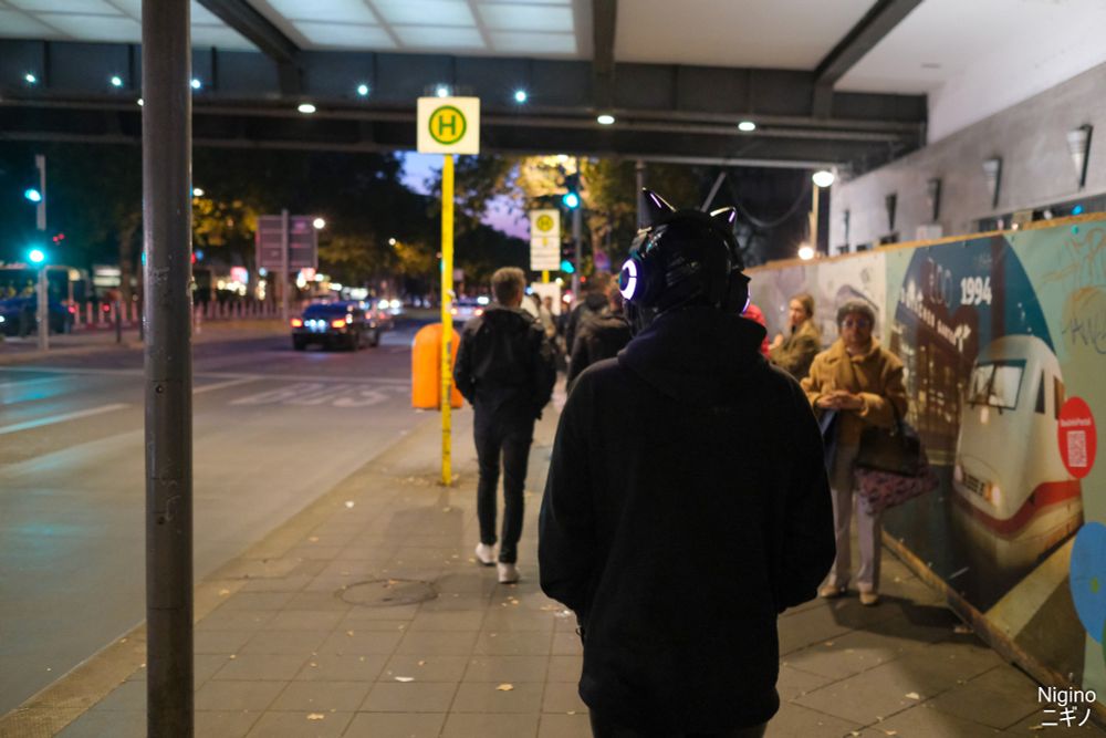 A latex drone wearing a hoodie, walking through the streets of Berlin 