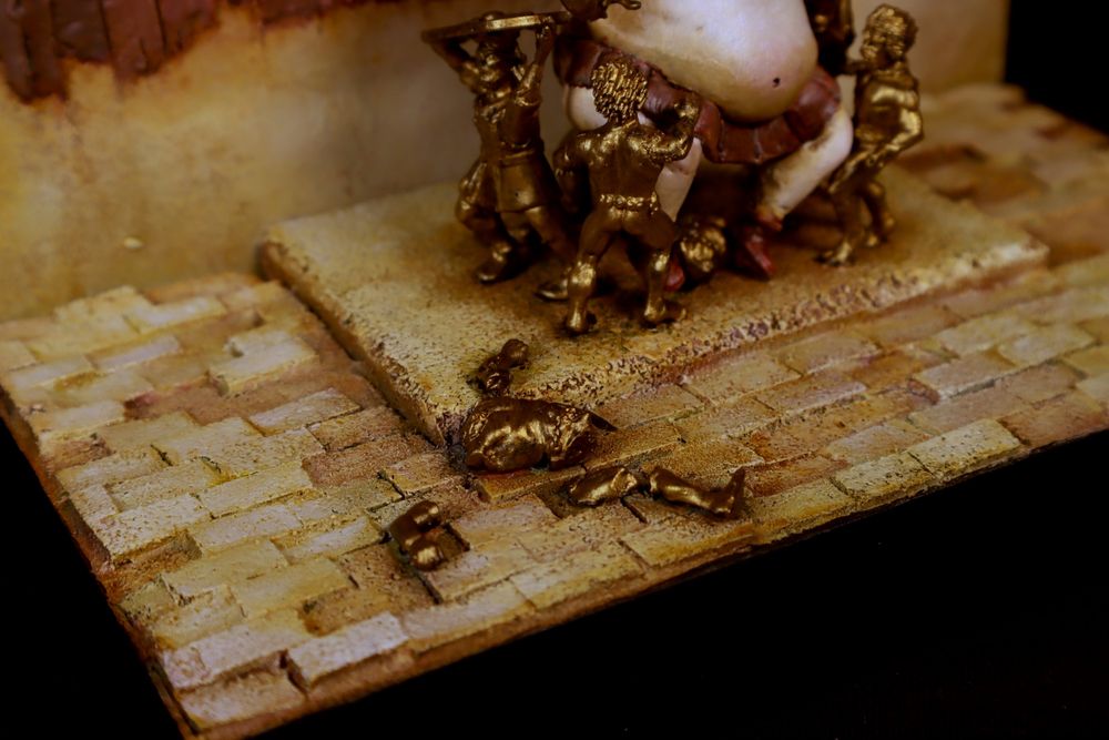 A shattered golden statue of a man, part of the golden throne. 