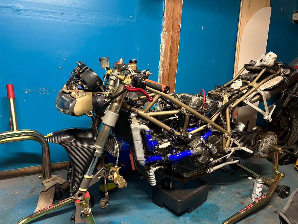 Photo of a stripped down Ducati 748 on stands, awaiting wheels and body work. 