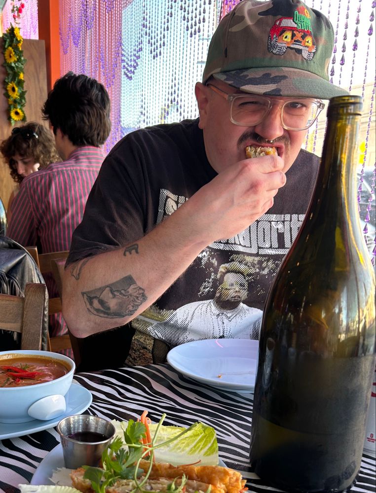 Photo of Jim Coleman Howes melting his face off with Vietnamese food. 