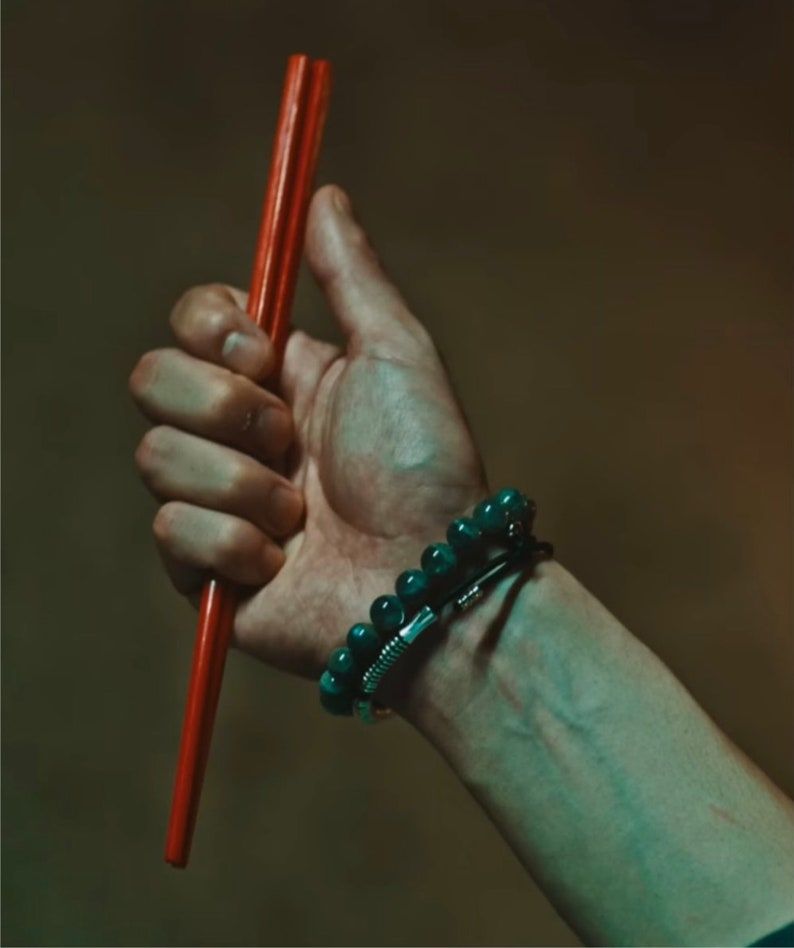 Hand holding red chopsticks