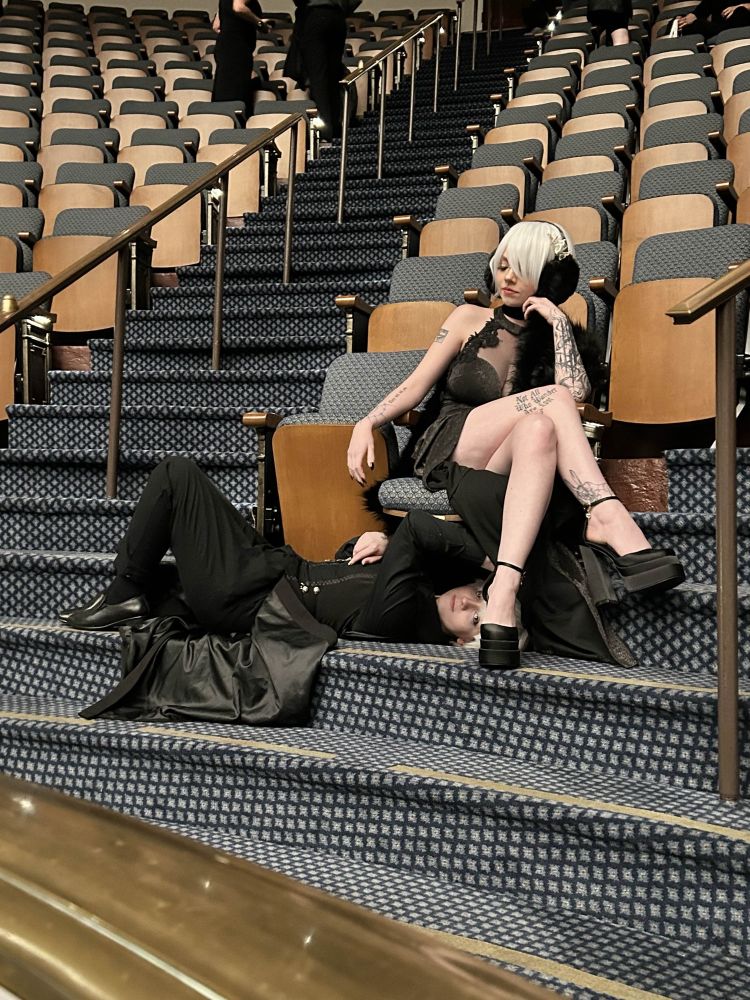 Me acting up in the concert hall by crawling around under a chair Daveed is sitting in. 