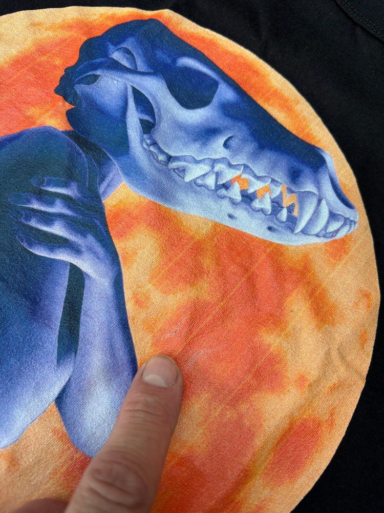 Photo of a misprinted t-shirt. The image has vertical stripes, probably caused by clogged print nozzles on the printer used to make the shirt. There should have been a quality control process to keep this from going out the door.
