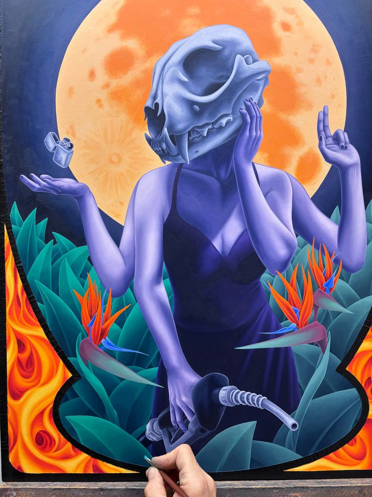 Oil painting in progress of a woman with a lynx skull for a head, with 4 arms. One hand is holding a hose from a gas pump, one hand is on her cheek, one holds up 2 fingers, one is palm up with a zippo lighter floating just above. She is surrounded by plants and bird of paradise flowers. The full moon rises behind her.