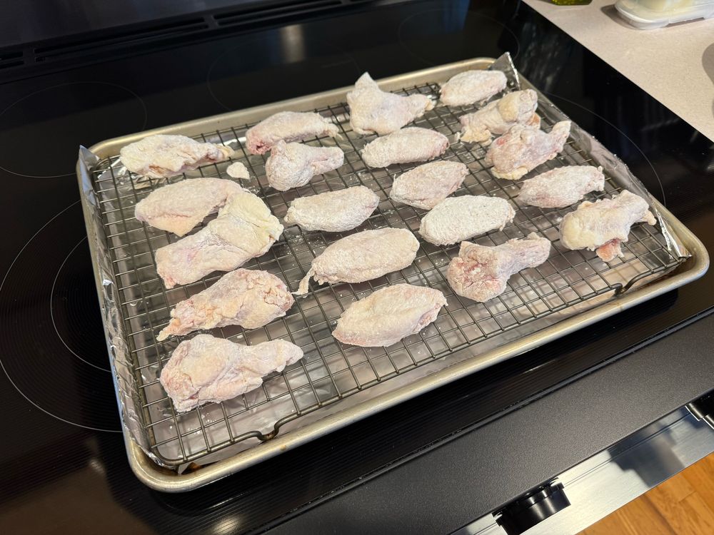A tray of uncooked chicken wings ready to go into the oven. 