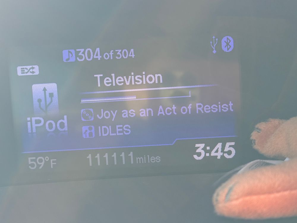 A picture of my car radio that shows I hit 111,111 miles in my car. 