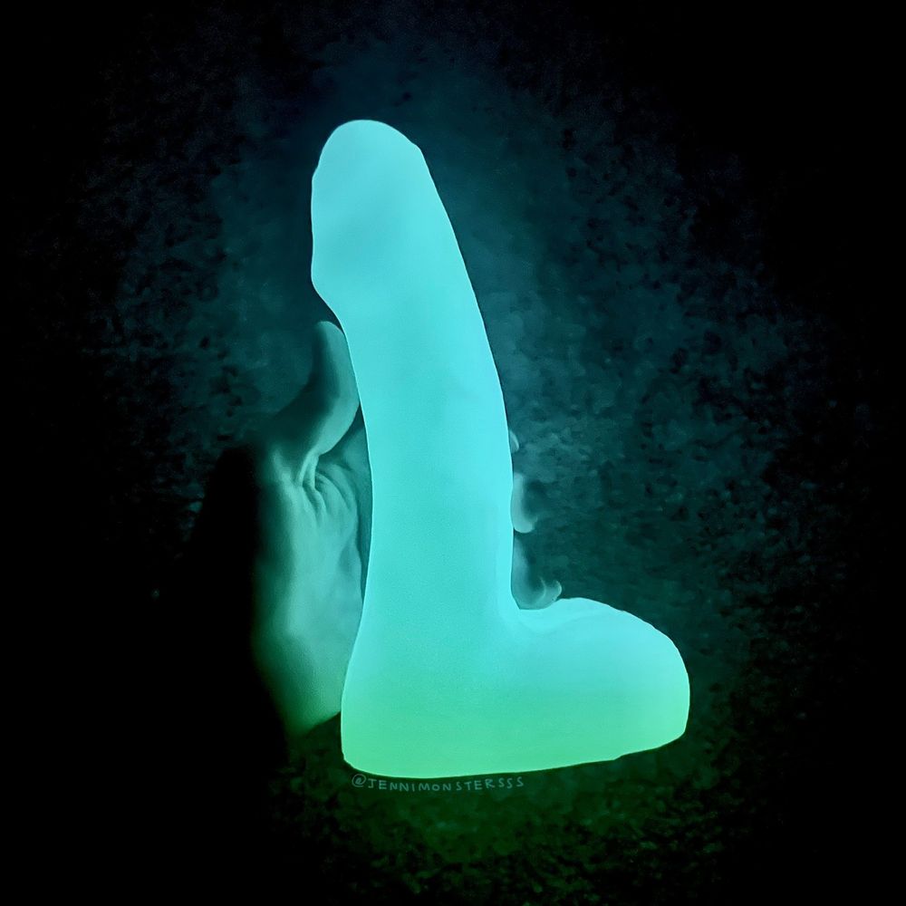 Glowy bluish-white dildo in a dark closet (from Bad Dragon)