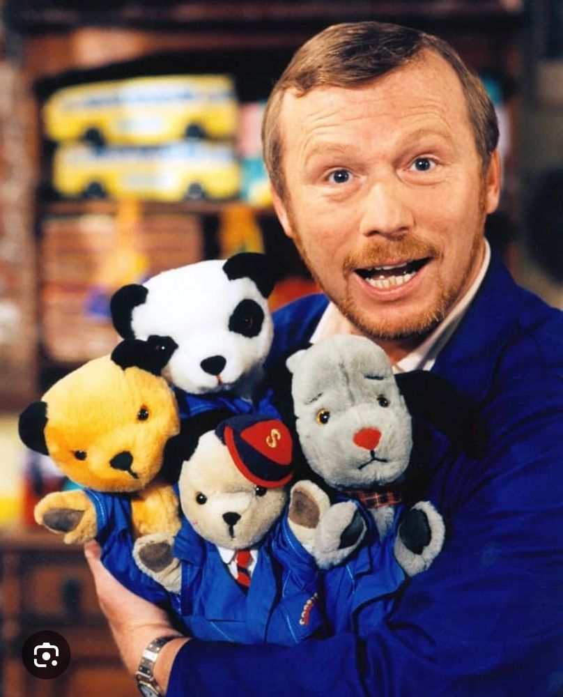 UK kids entertainer Matthew Corbett, fully clothed and holding a number of the hand puppets he was famous for working with