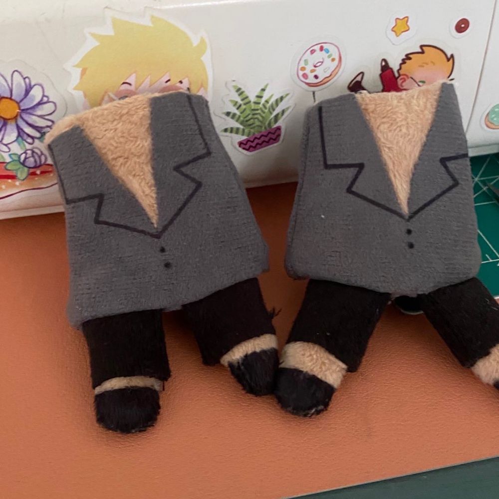 Two plushie bodies without heads, featuring an open grey shirt and black pants