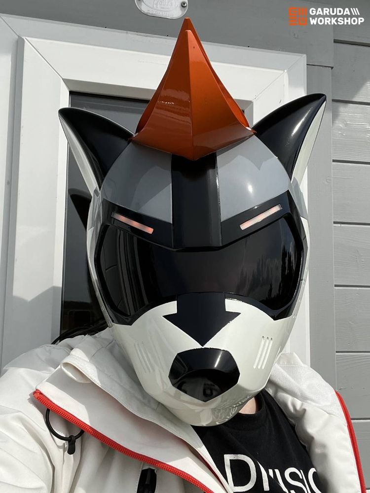 White & grey raccoon helmet with large black visor, sculpted orange hair and orange lights