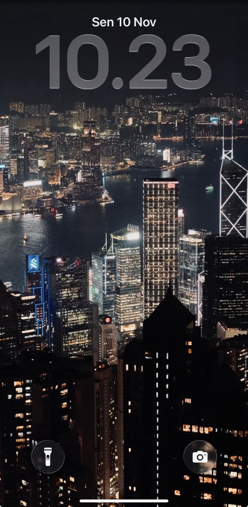 Wallpaper on iphone showing Hong Kong at night with many skyscraper buildings.