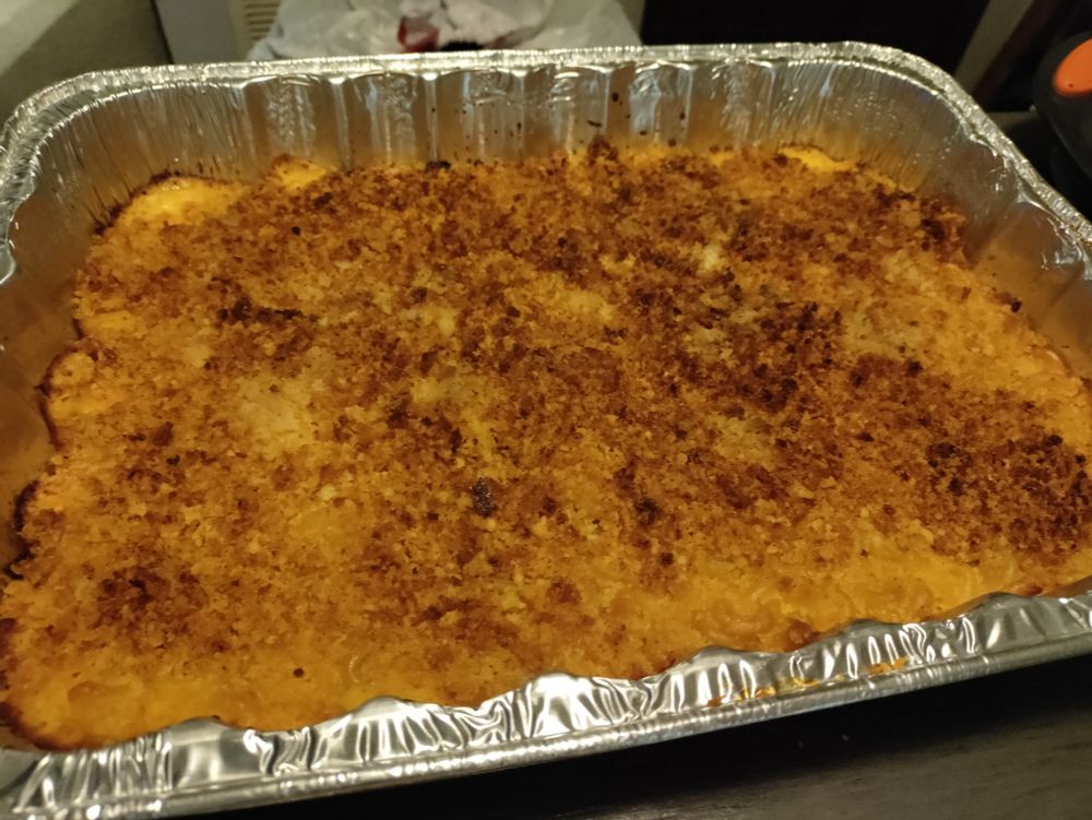 Homemade baked macaroni and cheese with a golden crust on top. It has bread crumbs and melted cheddar