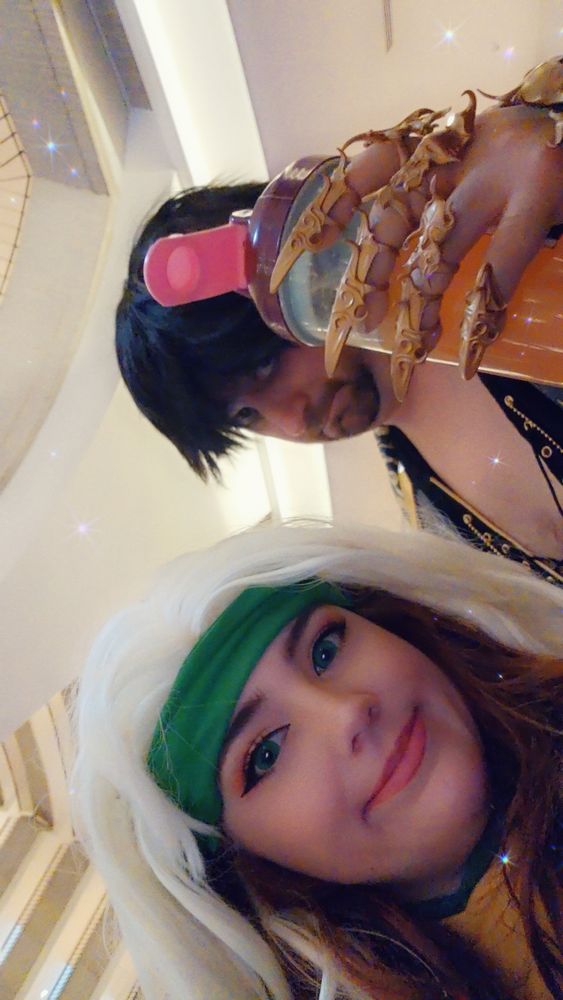 A selfie of Katie dressed in a #cosplay of rogue from xmen. With a friend dressed as gortash from baldurs gate holding up a gamersupps cup 