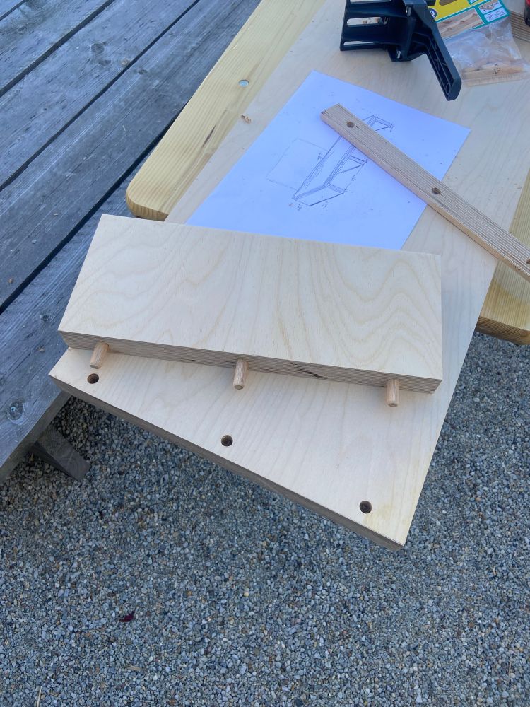 Two pieces of plywood with drilled holes and wooden plugs