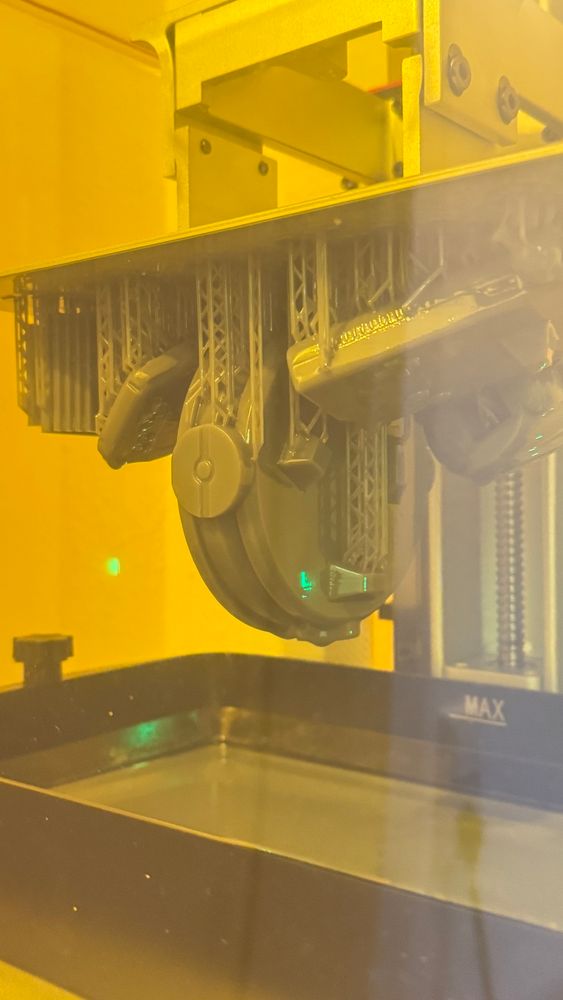 Bild eines Resin 3D Drucks, wo die Teile noch abtropfen und an der Platte hängen. 