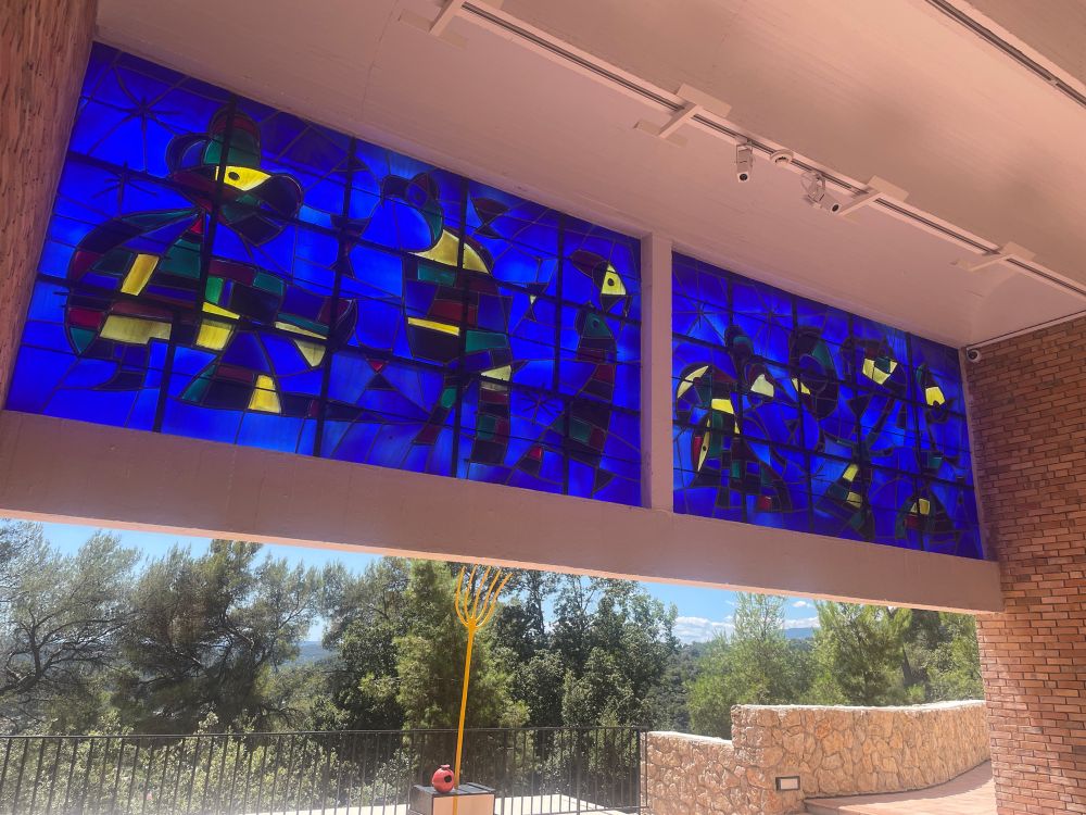 Un vitrail de Joan Miro, bleu, accroché en hauteur sur une terrasse à la fondation Maeght st paul de Vence. 