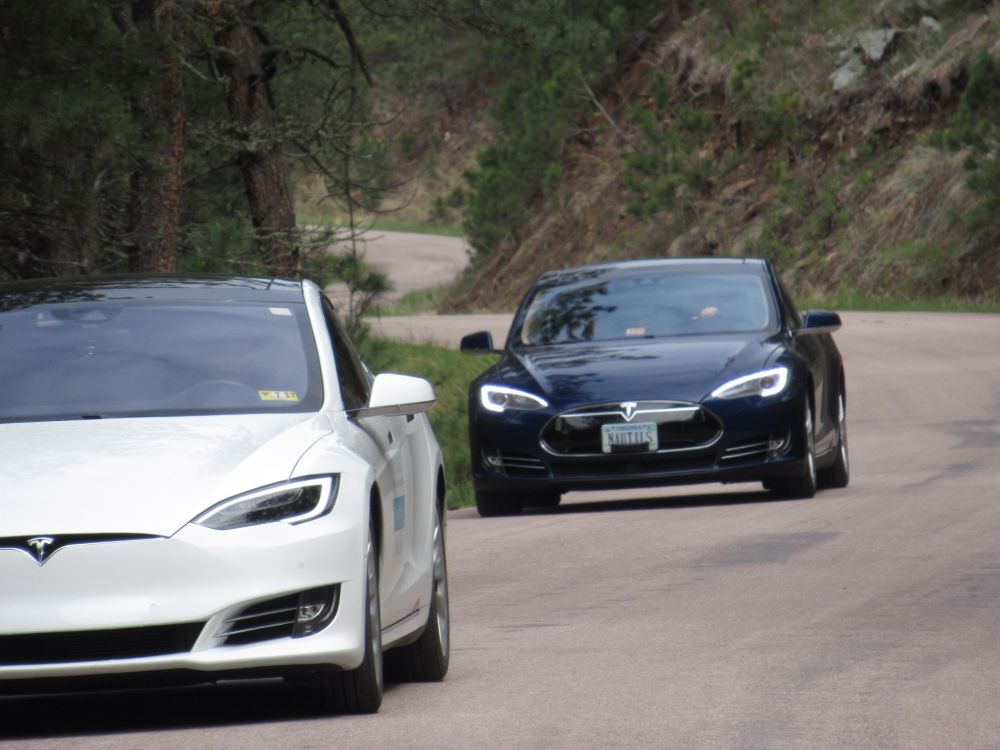 Two Tesla Model S on a curvy road in Custer State Park in South Dakota. 