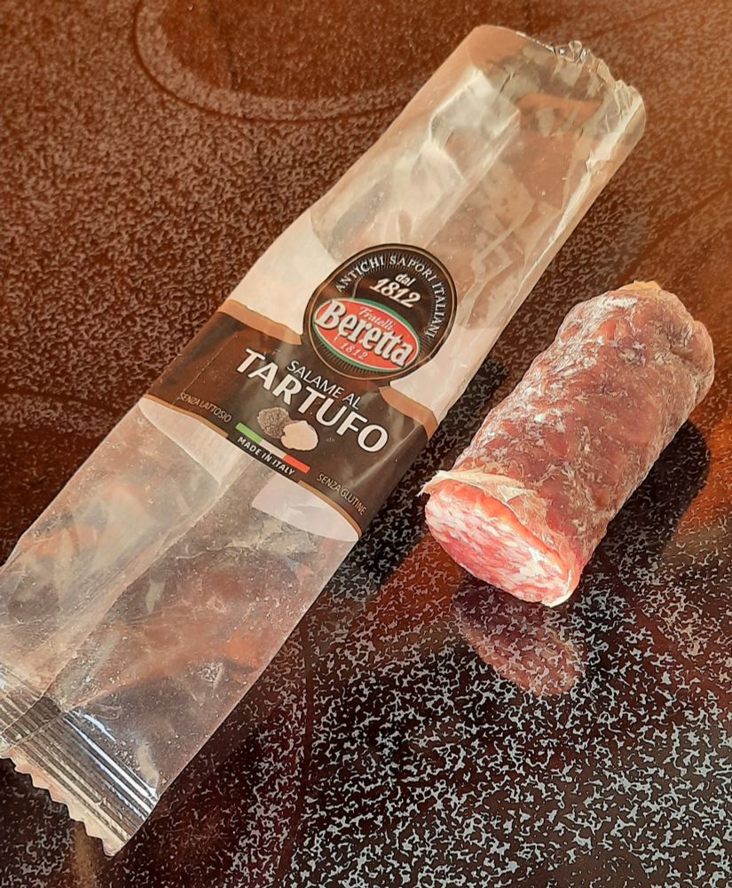 Eine angebrochene Salami-am-Stück-Verpackung des italienischen Herstellers Beretta. Das letzte Stück der Salami, maximal noch die Hälfte, liegt daneben.