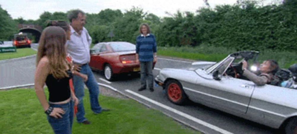 a couple of people standing next to a silver car with a license plate that says jct