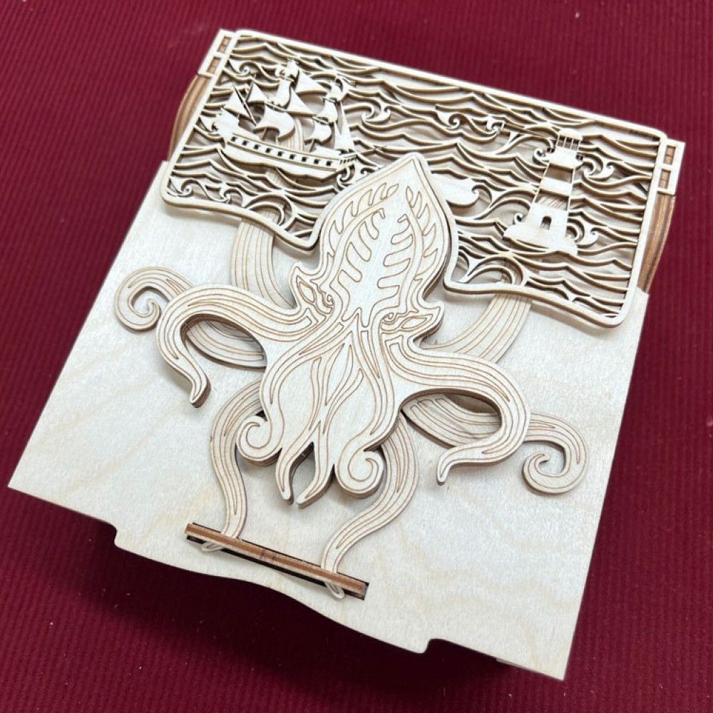 A curio box with a beast with tentacles on the lid. Moving a tentacle locks the box. This version has a ship and lighthouse add-on at the top of the box for Our Flag Means Death fans.
