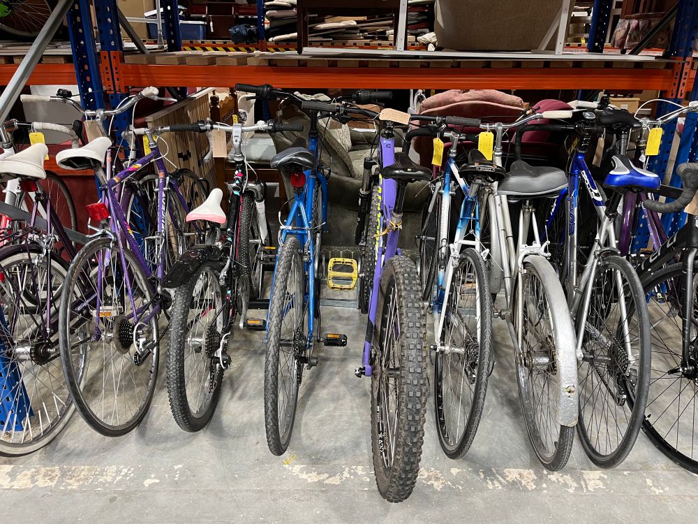 A row of swcond hand bikes of different sizes and colours