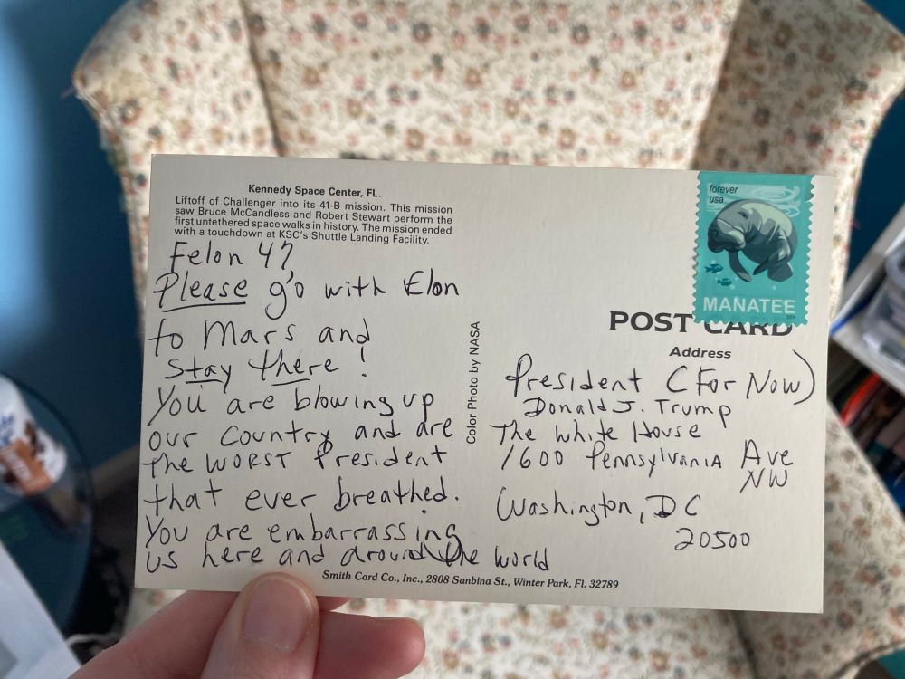 A handwritten postcard addressed to “President (For Now) Donald J Trump” at the 1600 Pennsylvania Ave White House address. The message reads “Felon 47, Please go with Elon to Mars and STAY THERE! You are blowing up our country and are the worst president that ever breathed. You are embarrassing us here and around the world”