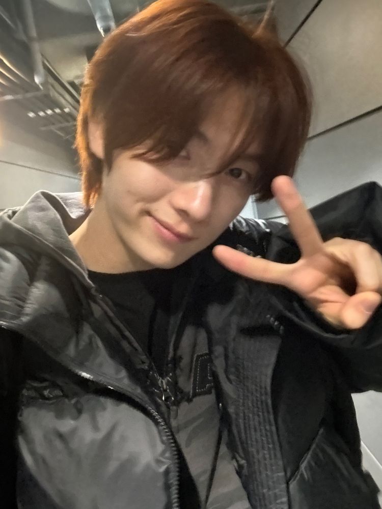 Youngjae selfie in black winter jacket with v hand sign