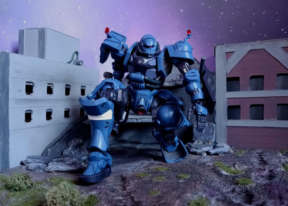 A Police Zaku stoops down to inspect the ground at their feet.  