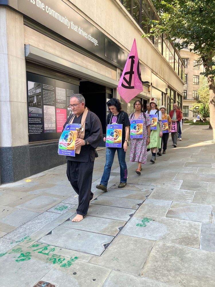 Group of people with simple placards on a walking meditation 