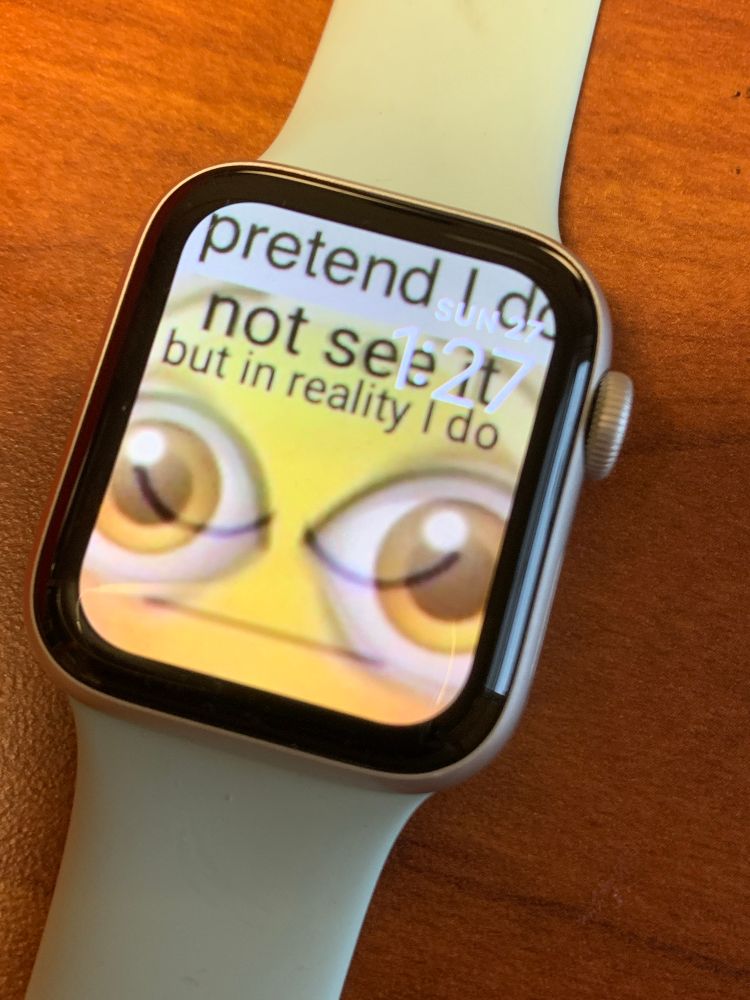 meme from camera roll shown on an Apple Watch’s background. It’s a combination of a neutral eyes closed emoji overlaid with two large eye emojis. It says “I pretend I do not see it but in reality I do”