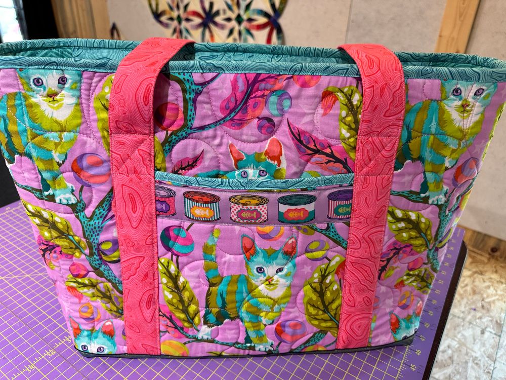 Back has a slip pocket, with ribbon trim (cat food cans!)