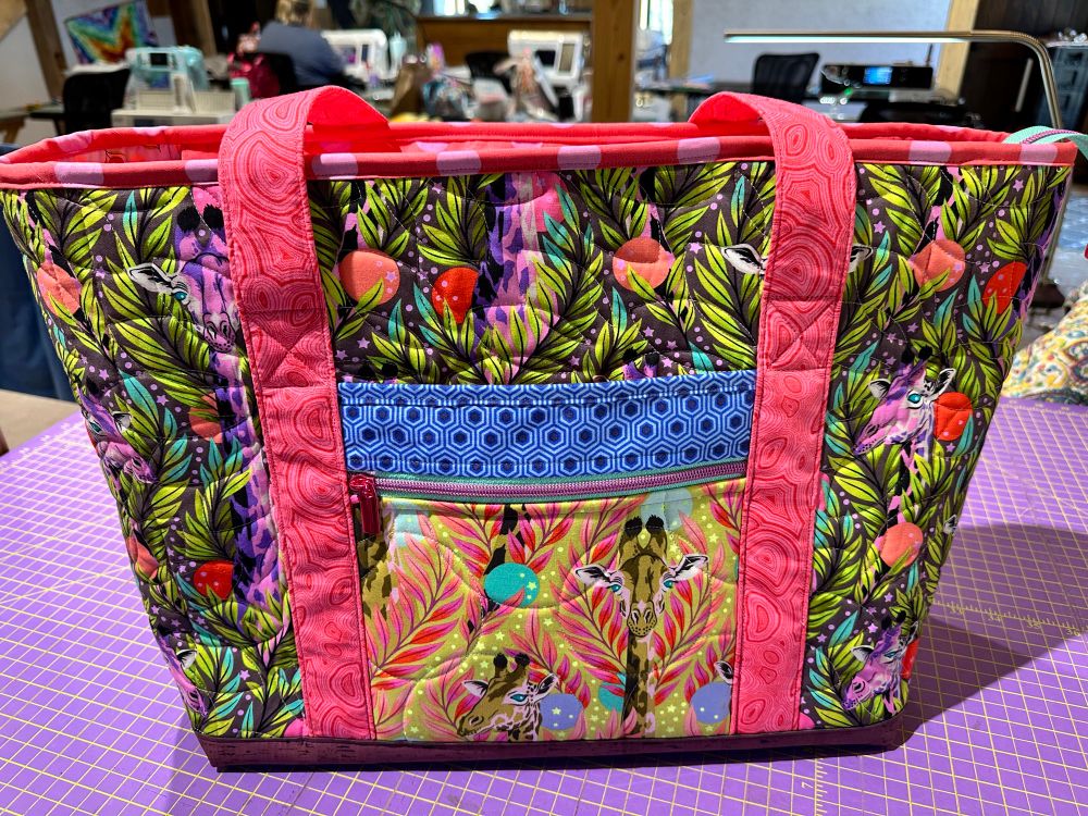 Front of tote, zip pocket and slip pocket. Fabric has giraffes. 